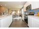 Bright, open kitchen with stainless steel appliances, island, and view of the dining and living areas at 5879 Handbell Ln, Greenwood, IN 46143