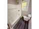 Bright bathroom with a new tub and shower combination, along with a modern toilet under a natural-lit window at 638 W 30Th St, Indianapolis, IN 46208