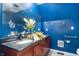Bathroom with a cherry wood vanity, black marble countertop, and blue painted walls at 671 State Road 267, Mooresville, IN 46158