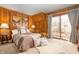 Cozy bedroom features wood paneling, soft lighting, and a sliding glass door to the outdoors at 671 State Road 267, Mooresville, IN 46158