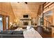 Cozy living room with hardwood floors, stone fireplace, a spiral staircase to loft, and comfortable seating at 671 State Road 267, Mooresville, IN 46158