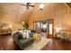 Bright living room with a stone fireplace, wood paneled walls, hardwood floors, and comfortable seating at 671 State Road 267, Mooresville, IN 46158