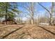 Lawn of the property filled with trees and fallen leaves, and a glimpse of the lake at 671 State Road 267, Mooresville, IN 46158
