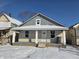 Charming home featuring a covered porch, and snow-covered yard, offering a cozy curb appeal at 724 E Beecher St, Indianapolis, IN 46203