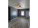 An open living room featuring newly installed flooring, a ceiling fan, and a bright window at 724 E Beecher St, Indianapolis, IN 46203