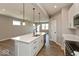 Bright, open kitchen with white cabinets, stainless steel appliances, and a large center island with seating at 7367 Broadview Ln, McCordsville, IN 46055
