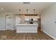 Open-concept kitchen features white cabinets, stainless steel appliances, a large island, and wood-look flooring at 7367 Broadview Ln, McCordsville, IN 46055