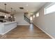 Bright and open living space with hardwood floors connecting the kitchen to a staircase at 7367 Broadview Ln, McCordsville, IN 46055