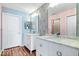 Bright bathroom featuring double sink vanity, a mirror, and flamingo wallpaper at 7415 Chapel Villas Dr # D, Indianapolis, IN 46214