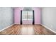 Spacious bedroom with vaulted ceiling, modern flamingo wallpaper and hardwood flooring throughout at 7415 Chapel Villas Dr # D, Indianapolis, IN 46214