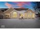Charming home featuring neutral siding, stone accents, snow-covered lawn, and picturesque sunrise at 7415 Chapel Villas Dr # D, Indianapolis, IN 46214