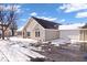 Charming home exterior featuring stone accents, a two-car garage, and winter landscaping on a bright day at 7415 Chapel Villas Dr # D, Indianapolis, IN 46214