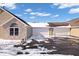 View of the multiple garages with snow in the driveway of the house, with stone accents and a modern design at 7415 Chapel Villas Dr # D, Indianapolis, IN 46214