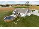 Aerial view of home's backyard featuring a deck with an above ground pool and large grass area at 8225 W 825 N, Thorntown, IN 46071