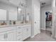 Bright bathroom featuring double sinks, white cabinets, and a walk-in closet at 8225 W 825 N, Thorntown, IN 46071