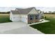 Aerial view of a home showcasing the brick and vinyl exterior, attached garage, and concrete driveway at 8225 W 825 N, Thorntown, IN 46071