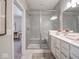 Modern bathroom with white dual vanity, quartz countertop, walk in glass shower, and tile flooring at 8660 Hudson Way, Brownsburg, IN 46112