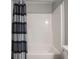 Clean bathroom includes a white shower and tub with a black and grey striped shower curtain at 8660 Hudson Way, Brownsburg, IN 46112