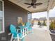 Cozy covered patio with bright blue furniture, ceiling fan, and serene views at 8660 Hudson Way, Brownsburg, IN 46112