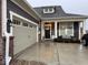Charming home showcasing a two-car garage, covered porch with seating, and impeccable landscaping at 8660 Hudson Way, Brownsburg, IN 46112