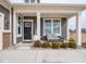 Inviting covered front porch with seating area, decorative plants, and ample natural light at 8660 Hudson Way, Brownsburg, IN 46112