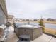 Cozy hot tub in the backyard with views of the pond, grill, and patio area enhance outdoor living at 8660 Hudson Way, Brownsburg, IN 46112