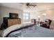 Bright main bedroom with a ceiling fan, dresser, TV, and comfortable seating area at 8660 Hudson Way, Brownsburg, IN 46112