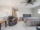 Relaxing main bedroom featuring a ceiling fan, bedside tables, and a comfortable seating area at 8660 Hudson Way, Brownsburg, IN 46112