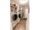 Functional laundry room features modern washer and dryer, shelving for storage, and durable flooring at 8724 Faulkner Dr, Indianapolis, IN 46239