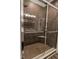 Modern tiled shower has clear glass doors and bronze fixtures with a built-in seat and shelf at 8724 Faulkner Dr, Indianapolis, IN 46239