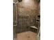 Tiled shower features bronze fixtures, a built-in seat and convenient shelving for toiletries at 8724 Faulkner Dr, Indianapolis, IN 46239