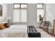 Bedroom with a large windows, decorative chair and ottoman, and stylish decor at 877 N East St # 103, Indianapolis, IN 46202