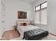 Bright bedroom features hardwood floors, neutral walls, and natural light from the window at 877 N East St # 103, Indianapolis, IN 46202