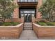 Inviting entrance with brick planters and landscaped greenery leading to double glass doors at 877 N East St # 103, Indianapolis, IN 46202