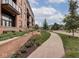 Apartment exterior showing landscaping with walking path, brick facade, and balconies at 877 N East St # 103, Indianapolis, IN 46202
