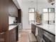 The kitchen boasts sleek, dark wood cabinets and stainless steel appliances against a minimalist backsplash at 877 N East St # 103, Indianapolis, IN 46202