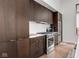 A kitchen showcases rich, dark wood cabinets with stainless steel appliances and a clean, bright backsplash at 877 N East St # 103, Indianapolis, IN 46202