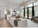 Open-concept living area with floor-to-ceiling windows, a statement chandelier, and a chef's kitchen at 877 N East St # 103, Indianapolis, IN 46202