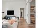 Bright living room with hardwood floors, comfortable seating and access to storage behind a sliding door at 877 N East St # 103, Indianapolis, IN 46202
