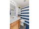 Functional bathroom features vanity, toilet, blue striped shower curtain and tile flooring at 10404 Kings Gap Way, Indianapolis, IN 46234