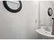 A half-bath boasts a modern vanity, decorative mirror, and neutral walls, creating a minimalist, stylish space at 10404 Kings Gap Way, Indianapolis, IN 46234