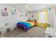 Bright bedroom with carpet, ceiling fan, rainbow bedding and large windows for natural light at 10404 Kings Gap Way, Indianapolis, IN 46234