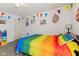 A playful bedroom features a rainbow comforter, cheerful decorations and a fun, inviting atmosphere at 10404 Kings Gap Way, Indianapolis, IN 46234