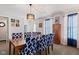 Dining room boasts stylish blue patterned chairs, wood table and cabinet with natural light at 10404 Kings Gap Way, Indianapolis, IN 46234