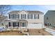 Charming two-story home with blue shutters, a welcoming front porch, and a well-maintained lawn in winter at 10404 Kings Gap Way, Indianapolis, IN 46234