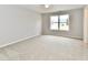 Neutral carpeted bedroom offers a window and light paint at 10669 Springston Ct, Fishers, IN 46037