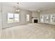 Spacious living room with neutral carpet, fireplace, large windows, and a ceiling fan with doors to the rear yard at 10669 Springston Ct, Fishers, IN 46037