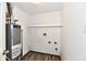 Utility room with water heater, shelving and hook ups for laundry machines and wood look floor at 10669 Springston Ct, Fishers, IN 46037