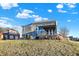 View of the backyard of the house with patio area covered by pergola and large windows at 1083 Margate Dr, Greenwood, IN 46143