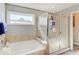 Bright bathroom with a glass-enclosed shower and separate soaking tub next to a sunny window at 1083 Margate Dr, Greenwood, IN 46143